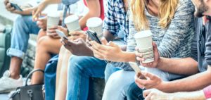 People sitting with coffee looking at smart phones